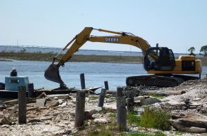 An excavator dumps oyster shell on an oyster boat in Apalachicola Bay.