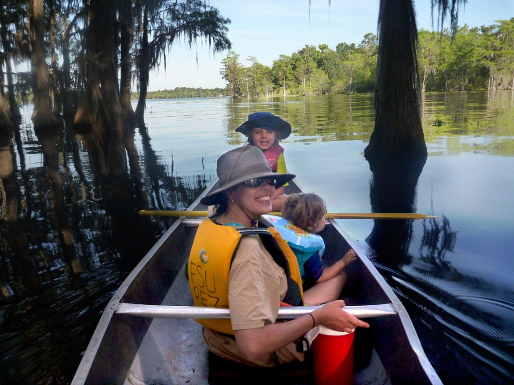 A family of four canoes out into Lake Bradford in tallahassee, Florida.