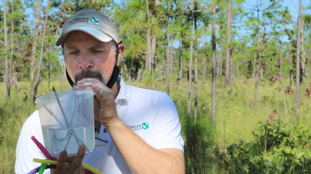 Brian Pelc (The Nature Conservancy of Florida) demonstrates th difference between sipping plants, and chugging plants using a container with water and color coded straws,