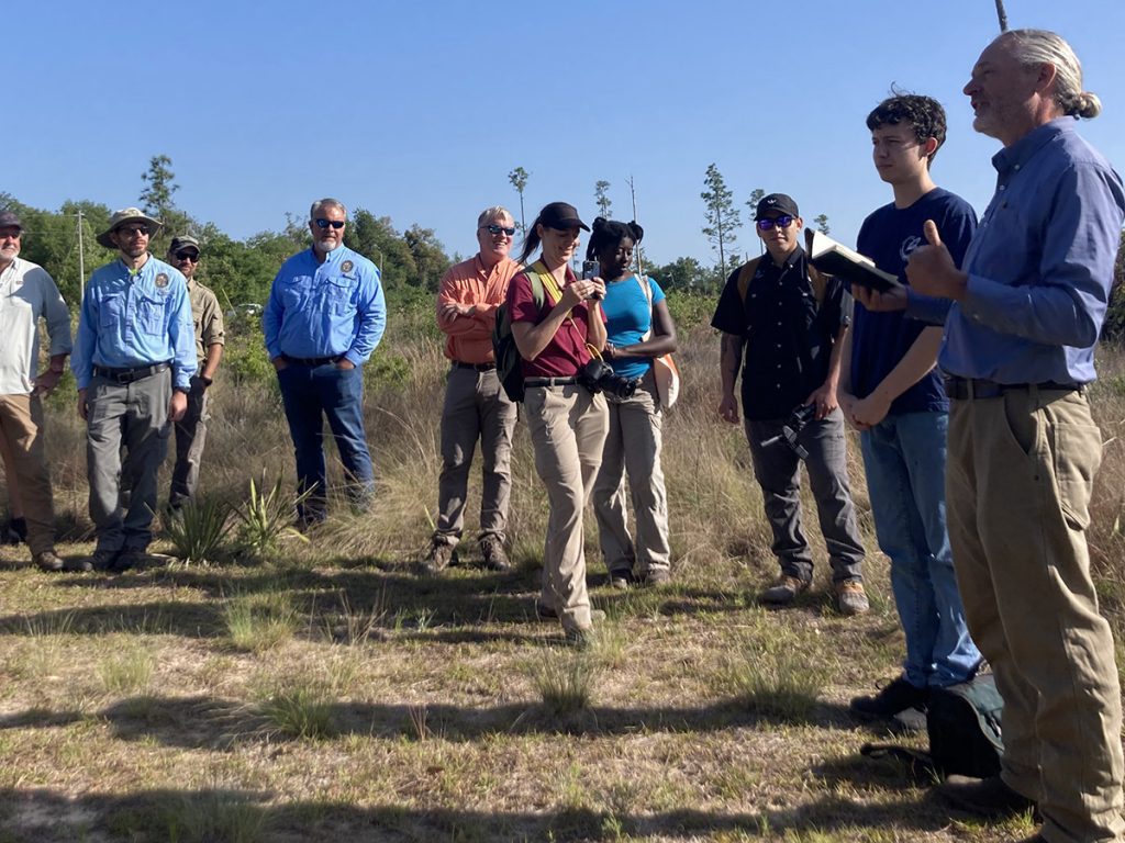 David Printiss (holding a journal), The Nature Conservancy’s North Florida Program Manager, thanks Jacob (standing next to David ), a young volunteer who has donated his time to go through the many, many photos taken by game cameras sitting outside gopher tortoise holes.